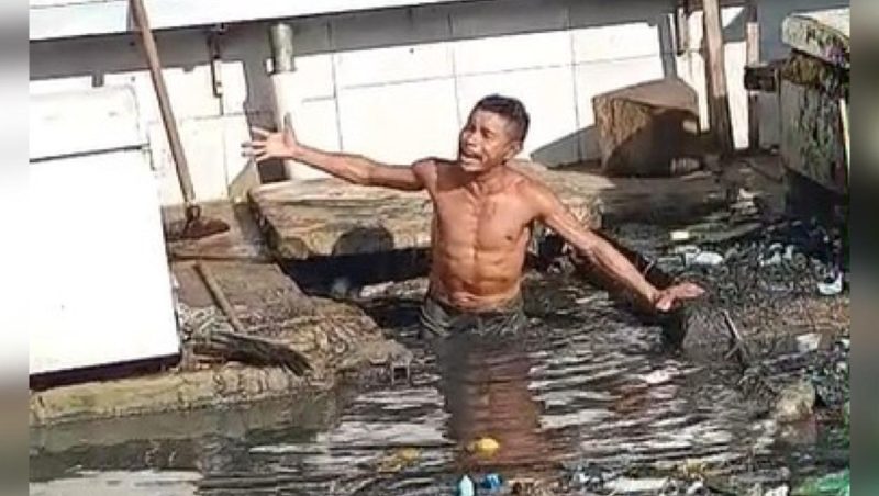 Homem limpa bueiro com as próprias mãos em feira de Manacapuru