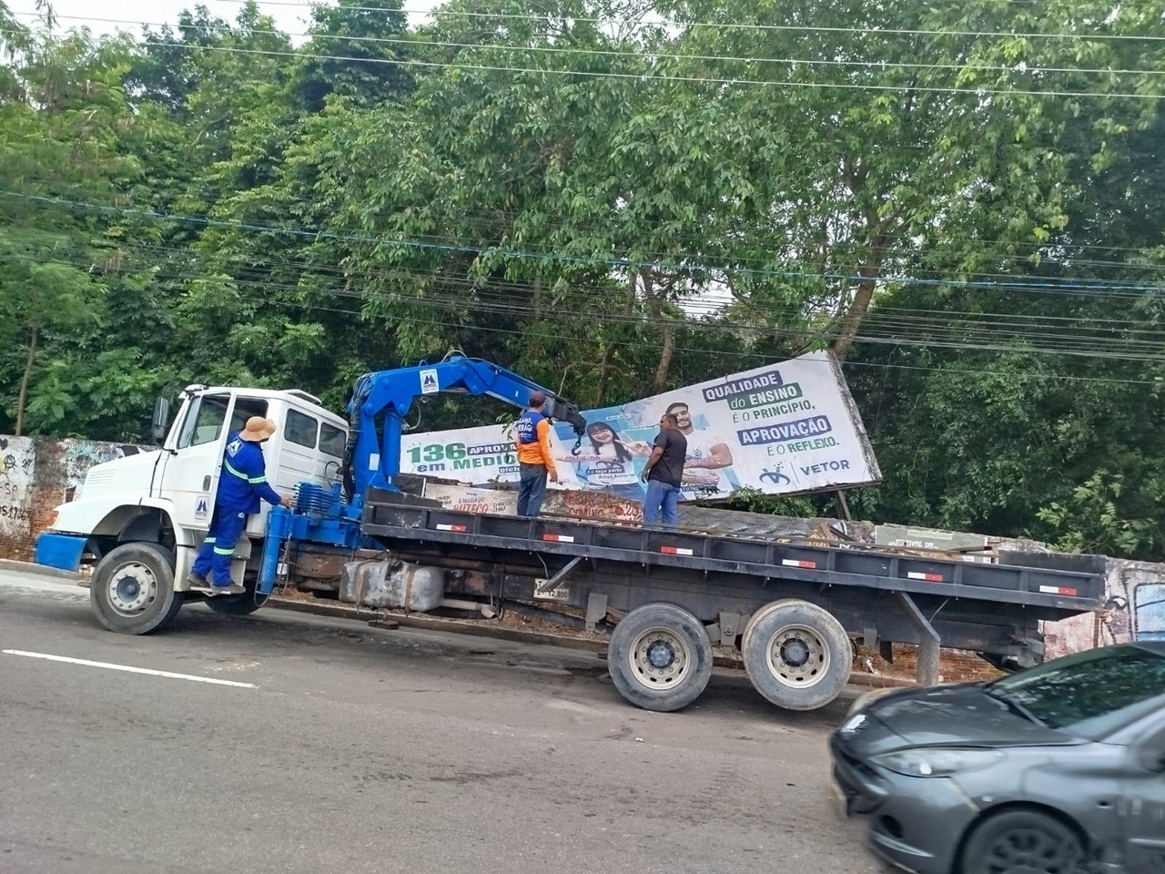 Equipe do Implurb executando a retirada de outdoors em área de obra do complexo viário “Passarão”