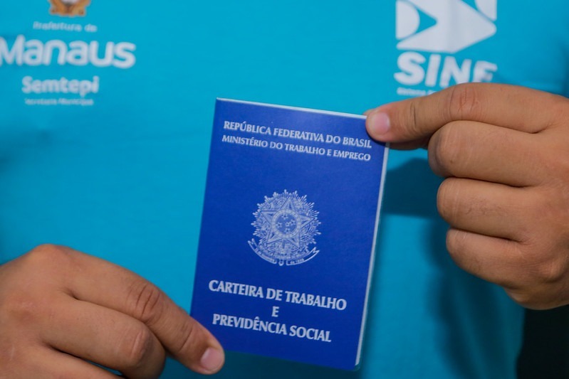 Mãos segurando carteira de trabalho